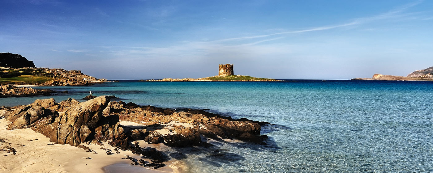 north-Sardinian coast, clear turquoise water and in the background the Spanish Tower of Isola Rossa